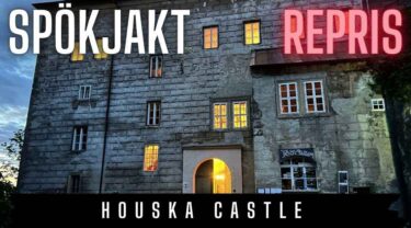 Spökjakt repris på Houska Castle – stenborg med upplysta fönster på kvällen